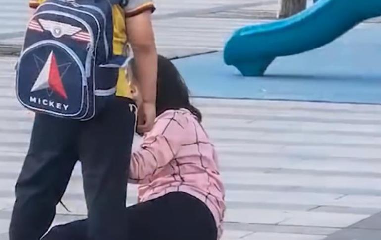 男孩街头猛扯母亲头发施暴 妈妈竟然还低着头微笑
